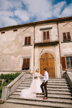 The wedding couple walks in the garden. Lovers of the bride and groom. Wedding in Florence, Italy, in an old villa-winery.