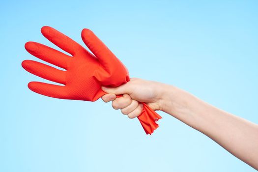 inflated rubber red glove in hand blue background and house cleaning. High quality photo