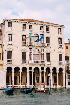 Old houses on Grand Canal, Venice, Italy. Vintage hotels and residential buildings in Venice center. Historical architecture of Venice on water in summer. Venetian street with ancient facades.