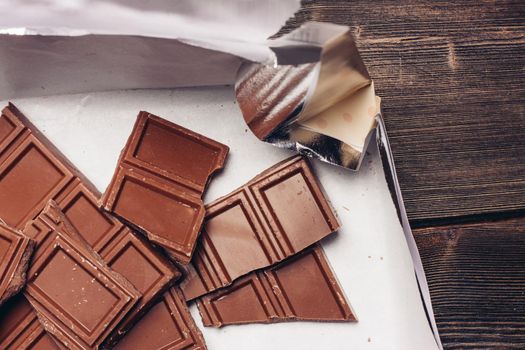 chocolate broken on brown paper on a delicacy table. High quality photo