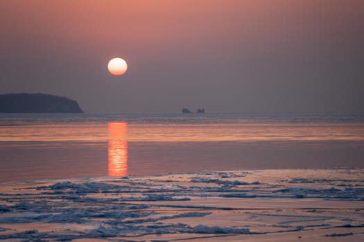 Seascape ice beach and the red sunset.