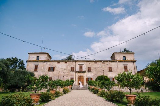 The wedding couple walks in the garden. Lovers of the bride and groom. Wedding in Florence, Italy, in an old villa-winery.