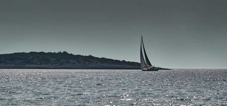 Beautiful sea landscape with lonely boat on the horizon, island is on background, colorful