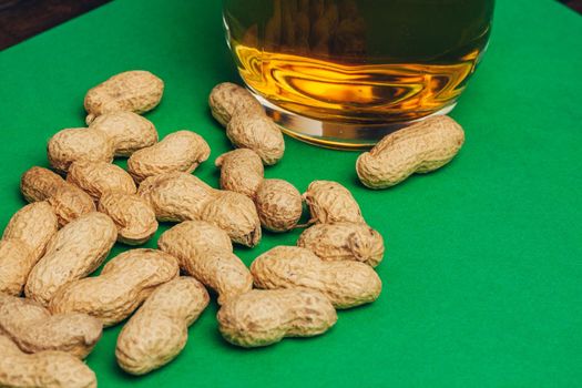 peanuts in shells mug beer green background bar. High quality photo