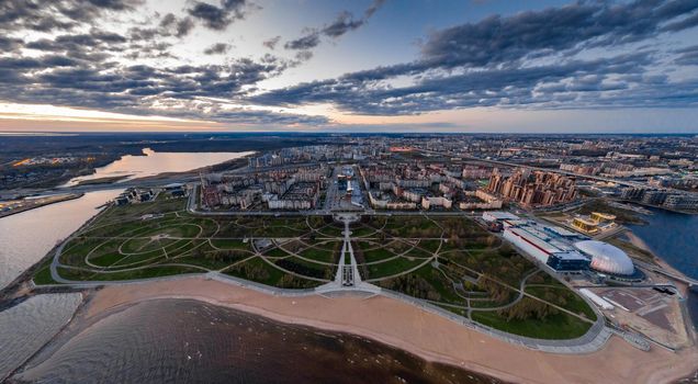 Russia, St.Petersburg, 06 May 2020: Aerial panoramic image of Primorskiy district at sunset, Park of 300 anniversaries, trade center Piterland, public beach, night illumination , dusk