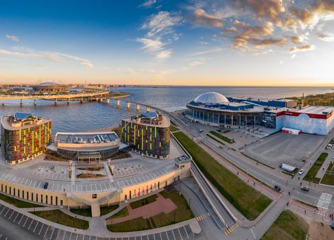 Russia, St.Petersburg, 06 May 2020: Aerial panoramic image of trade center Piterland at sunset, Park of 300 anniversaries and of Gazprom arena stadium, night illumination, dusk