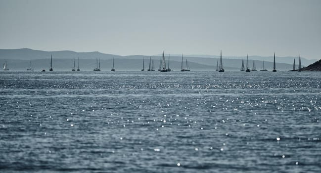 Beautiful sea landscape with sailboats, the race of sailboats on the horizon, a regatta, a Intense competition, island with windmills are on background