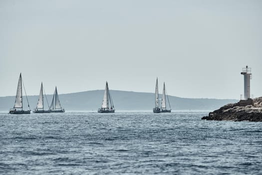 Beautiful sea landscape with sailboats, the race of sailboats on the horizon, a regatta, a Intense competition, island with windmills are on background