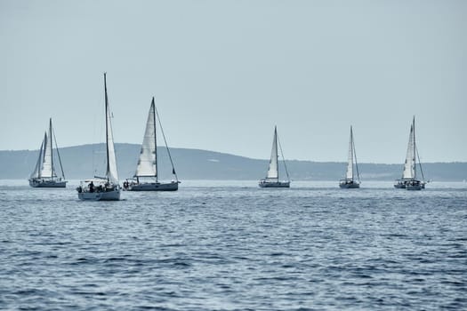 Beautiful sea landscape with sailboats, the race of sailboats on the horizon, a regatta, a Intense competition, island with windmills are on background