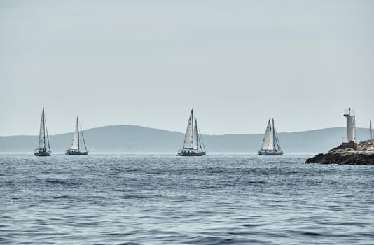 Beautiful sea landscape with sailboats, the race of sailboats on the horizon, a regatta, a Intense competition, island with windmills are on background