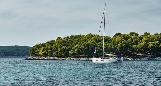 Beautiful sea landscape with lonely boat on the horizon, island is on background, colorful