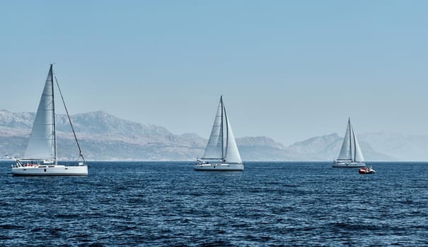 Beautiful sea landscape with sailboats, the race of sailboats on the horizon, a regatta, a Intense competition, island with windmills are on background
