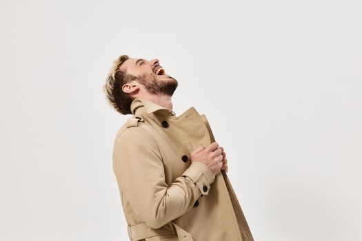 Cheerful man in coat laughing studio modern lifestyle lifestyle. High quality photo