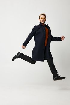 cute blond guy running to the side in fashion clothes trend of the season pants coat. High quality photo