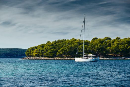 Beautiful sea landscape with lonely boat on the horizon, island is on background, colorful