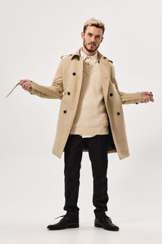 man in a beige coat fashionable hairstyle for autumn style Studio in full growth. High quality photo