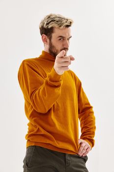 men with a serious expression points a finger forward fashion studio light background. High quality photo
