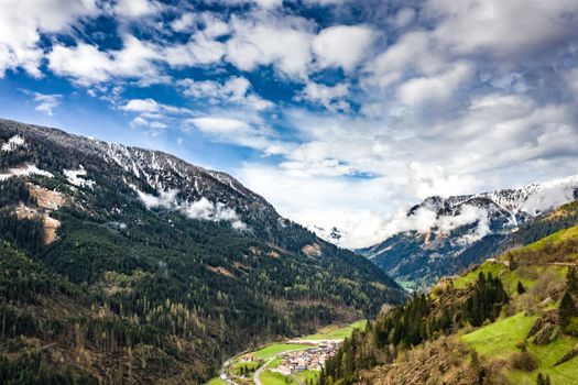 Aerial view of valley with green slopes of the mountains of Italy, Trentino, The trees tumbled down by a wind, huge clouds over a valley, green meadows, Dolomites on background