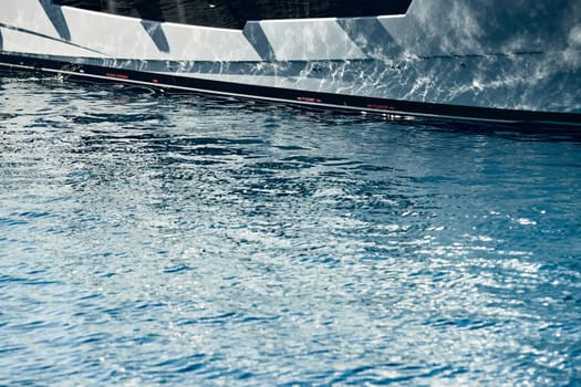 Board of the big boat, reflections of the sun on water at sunset, interesting texture, smooth lines of water