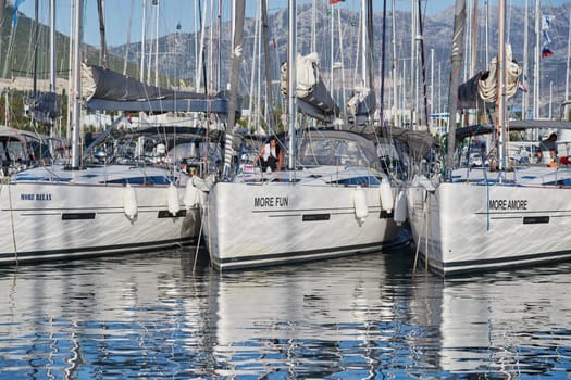 Croatia, Split, 15 September 2019: The number of sailboats with the blue sky and mountain on a background, a sail regatta, reflection of masts on water, ropes and aluminum