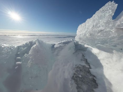 Ice slopes in sunny winter day, transparent ice of blue color, purely blue sky, long shadows, a pure snow-covered virgin soil, snow barkhans, . High quality photo