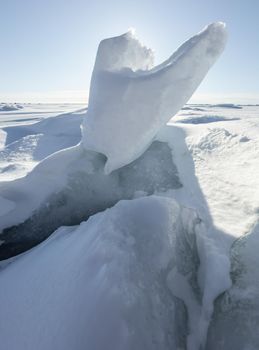 Ice slopes in sunny winter day, transparent ice of blue color, purely blue sky, long shadows, a pure snow-covered virgin soil, snow barkhans, . High quality photo