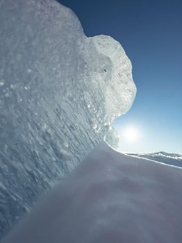 Ice slopes in sunny winter day, transparent ice of blue color, purely blue sky, long shadows, a pure snow-covered virgin soil, snow barkhans, . High quality photo