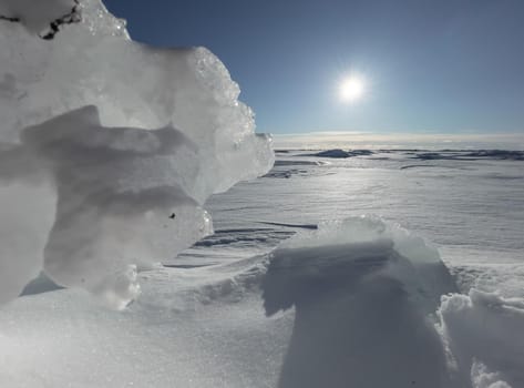 Ice slopes in sunny winter day, transparent ice of blue color, purely blue sky, long shadows, a pure snow-covered virgin soil, snow barkhans, . High quality photo