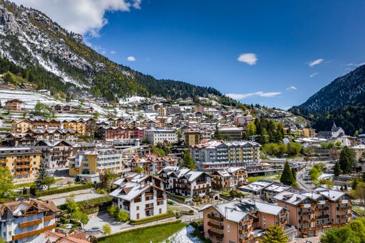 The Improbable aerial landscape of village Molveno, Italy, snow covered mountains Dolomites on background, roof top of chalet