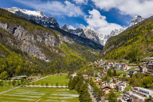 The Improbable aerial landscape of village Molveno, Italy, snow covered mountains Dolomites on background, roof top of chalet