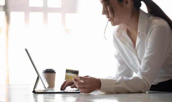 girl makes a purchase on the Internet on the smart tablet with credit card - online shopping concept