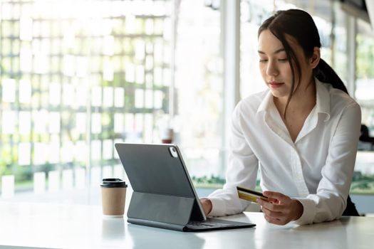 girl makes a purchase on the Internet on the smart tablet with credit card - online shopping concept