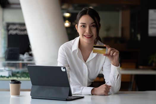 Young beautiful woman holding credit card at office.