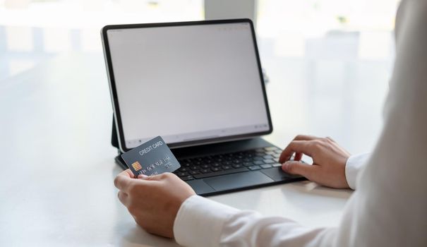 girl makes a purchase on the Internet on the smart tablet with credit card - online shopping concept