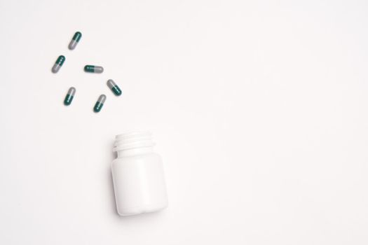 White jar with pills on a light background top view medicine health vitamins. High quality photo