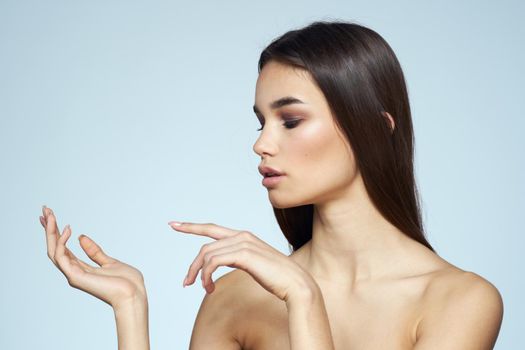 Woman with naked shoulders long hair clean skin cropped view blue background. High quality photo