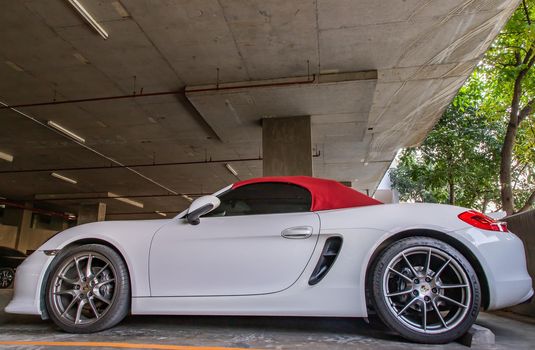 Bangkok, Thailand - 14 Jan 2021 : The side of Wheel of White Porsche Sports Car parked in the parking lot. Selective focus.