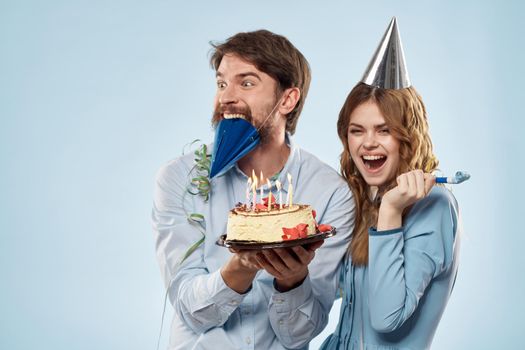Emotional man with cake and pretty woman party disco blue background. High quality photo