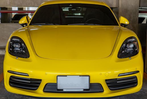 Bangkok, Thailand - 06 Jan 2021 : In front of yellow Porsche Sports Car parked in the parking lot. Selective focus.