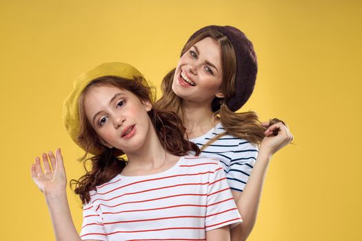 Mom and daughter embrace joy fun childhood lifestyle yellow background. High quality photo