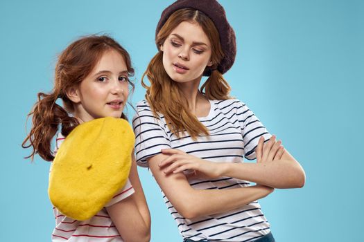 Fashion sisters in hats fun lifestyle blue background studio. High quality photo