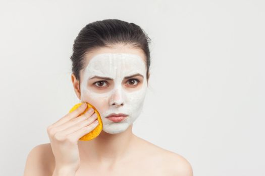 woman with bare shoulders cream mask on face scrub sponges. High quality photo