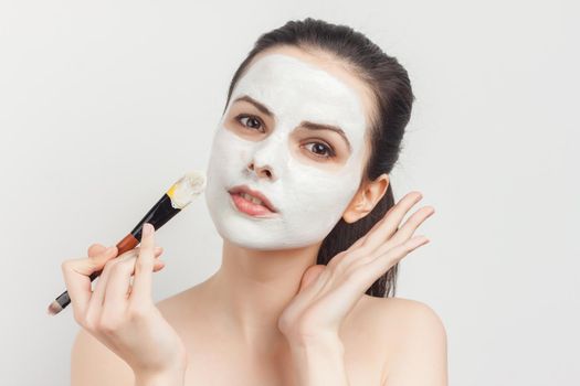 emotional brunette cream face mask bare shoulders cropped view clear skin. High quality photo