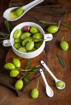 Olive oil and olive branch on black background.