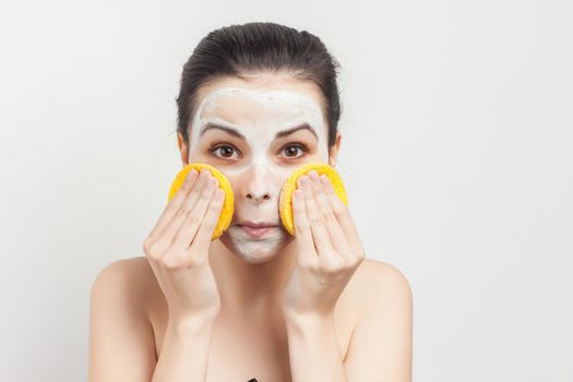 brunette with cream mask on the face naked shoulders. High quality photo