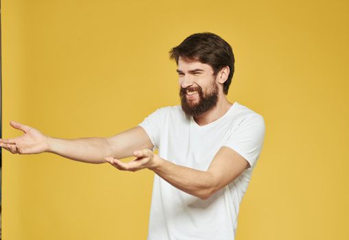 male model gesturing with his hands on a yellow background cropped view . High quality photo