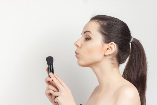 brunette bare shoulders face mask brushing cropped view. High quality photo