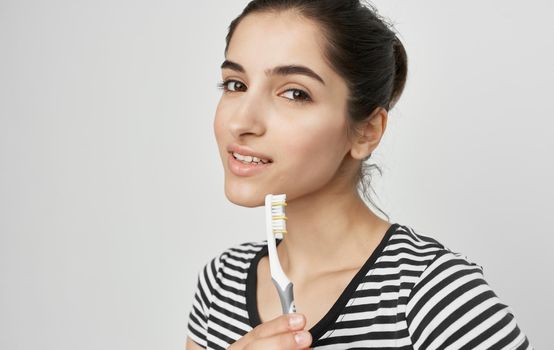 cheerful woman in striped t-shirt toothbrush hygiene. High quality photo