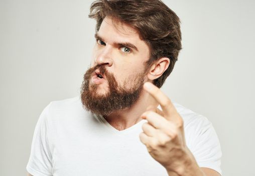 The guy in the T-shirt shows the index finger and emotions model an indignant look. High quality photo