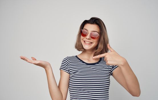 pretty woman in fashion clothes red skirt striped t-shirt sunglasses gesturing with hands. High quality photo